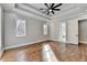 Main bedroom with hardwood floors, tray ceiling, and large windows, and access to bathroom at 3609 Centerville Rosebud Rd, Snellville, GA 30039