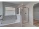 Relaxing bathroom with soaking tub, glass enclosed shower, and white tile at 16 Camellia Dr, Fairburn, GA 30213