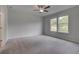Spacious bedroom with neutral carpet, ceiling fan, and two windows providing natural light at 16 Camellia Dr, Fairburn, GA 30213