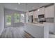 Bright kitchen features white cabinets, stainless appliances, pendant lighting, and hardwood floors at 16 Camellia Dr, Fairburn, GA 30213