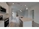Well-lit kitchen featuring an island with sink, stainless steel appliances, quartz countertops, and hardwood floors at 16 Camellia Dr, Fairburn, GA 30213