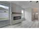 Cozy living room with wood-look floors, a contemporary fireplace, and bright windows at 16 Camellia Dr, Fairburn, GA 30213