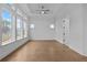 Well-lit bedroom with hard wood floors, white walls, ceiling fan, and multiple windows at 231 Strawberry Ln, Woodstock, GA 30189