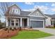 Attractive gray home with a two-car garage and well-kept landscaping enhances its charming curb appeal at 231 Strawberry Ln, Woodstock, GA 30189