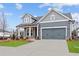 Stylish gray home featuring a well-maintained lawn, complemented by a two-car garage and inviting curb appeal at 231 Strawberry Ln, Woodstock, GA 30189