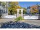 Community entrance featuring white gates, stone pillars, well-maintained landscaping, and cobblestone drive at 4100 Paces Se Walk # 1306, Atlanta, GA 30339