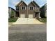 Two story townhome featuring a brown exterior, white trim, and attached garages at 3102-B Brownstone Se Ln, Atlanta, GA 30354