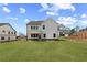 Backyard view of a two-story white home with a well-maintained lawn and landscaping at 7675 Homer Dr, Cumming, GA 30028