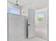 White tile walk-in shower with overhead shower fixture and bright window at 7675 Homer Dr, Cumming, GA 30028