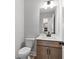 Modern half-bathroom with clean lines, contemporary fixtures, and wood cabinets at 7675 Homer Dr, Cumming, GA 30028