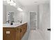 Bathroom with double sink vanity, large mirror, and tiled walk-in shower at 7675 Homer Dr, Cumming, GA 30028