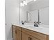 Bathroom featuring double sink vanity with a large mirror and modern lighting at 7675 Homer Dr, Cumming, GA 30028