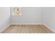 This bedroom features hardwood floors, light walls, and a window with views of the lawn at 7675 Homer Dr, Cumming, GA 30028
