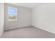 A bright bedroom is filled with natural light from the window and has neutral carpeting at 7675 Homer Dr, Cumming, GA 30028