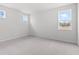 A spacious bedroom is brightened by natural light from the windows and complimented by neutral carpeting at 7675 Homer Dr, Cumming, GA 30028