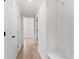Hallway with hardwood floors, white walls, and contrasting black door hardware at 7675 Homer Dr, Cumming, GA 30028