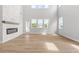 Airy living room boasts a floor-to-ceiling stone fireplace, expansive windows, and hardwood floors at 7675 Homer Dr, Cumming, GA 30028