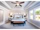 Comfortable main bedroom with tray ceiling, large bed, and natural light at 7675 Homer Dr, Cumming, GA 30028