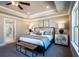 Main bedroom with tray ceiling, comfortable bed, and ensuite bathroom entrance at 7675 Homer Dr, Cumming, GA 30028