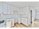 Open kitchen with white cabinets, quartz countertops and view into living area at 2502 Tupelo Se St, Atlanta, GA 30317