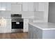 Modern kitchen with white cabinets, gray island, and stainless steel appliances at 2502 Tupelo Se St, Atlanta, GA 30317