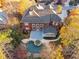 Aerial view of a home with a pool, backyard, and surrounding landscape with fall colors at 2195 Lake Shore Lndg, Alpharetta, GA 30005
