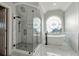 Elegant bathroom featuring a modern tub, glass shower, and decorative window at 2195 Lake Shore Lndg, Alpharetta, GA 30005