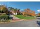 Beautiful curb appeal with a lush green lawn, mature trees, and a long driveway leading to the house at 2195 Lake Shore Lndg, Alpharetta, GA 30005