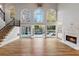 Bright living room with large windows, hardwood floors, fireplace, and staircase at 2195 Lake Shore Lndg, Alpharetta, GA 30005
