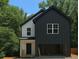 Charming two-story home with a black and white color scheme, attached garage, and lush green trees in the background at 1664 Crestridge Se Dr, Marietta, GA 30067