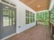 Inviting front porch with wooden ceiling, gray door, and wooded views at 1664 Crestridge Se Dr, Marietta, GA 30067