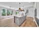 Bright, modern kitchen with a gray island, white counters, stainless appliances, and a view from large windows at 1664 Crestridge Se Dr, Marietta, GA 30067