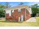 Back of a red brick house features a grassy yard and convenient access with a paved driveway at 1220 Hightower Nw Rd, Atlanta, GA 30318