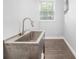 Bright laundry room features a stainless steel utility sink, modern faucet, and plank flooring at 1220 Hightower Nw Rd, Atlanta, GA 30318