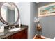 Elegant powder room with dark granite vanity and oval mirror at 1111 Valley Ridge Se Ct, Marietta, GA 30067