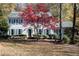 Two-story house with blue shutters, landscaping, and a tree with red leaves at 1111 Valley Ridge Se Ct, Marietta, GA 30067