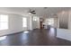 Open concept living room featuring hardwood floors, bright natural light, and a kitchen in the background at 516 Healy Dr # 69, Cumming, GA 30040