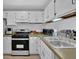 Galley kitchen with white cabinets, stainless steel appliances, and a double sink at 361 W Post Oak Sw Xing, Marietta, GA 30008