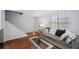 Inviting living room with hardwood floors, a gray sofa with decorative pillows, and a stairway at 2946 N Dekalb Dr # Apt C, Atlanta, GA 30340