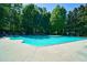 Community pool surrounded by green trees and lounge chairs at 2870 Pharr Court South Nw # 2602, Atlanta, GA 30305