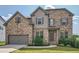 Charming two-story brick home with well-maintained lawn, two car garage, and professionally landscaped front yard at 207 Eagles Flight, Villa Rica, GA 30180