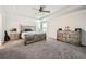 Spacious main bedroom featuring a tray ceiling, carpet flooring, and natural wood furniture at 207 Eagles Flight, Villa Rica, GA 30180
