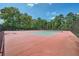 Community tennis court with vibrant surface, surrounded by lush greenery and fencing at 207 Eagles Flight, Villa Rica, GA 30180