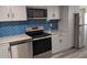 Open kitchen features stainless steel appliances, modern cabinets and countertops, and beautiful backsplash at 26 Reeves St, Norcross, GA 30071