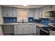 Modern kitchen features blue backsplash, light-colored cabinets, granite countertops and stainless steel appliances at 26 Reeves St, Norcross, GA 30071