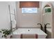 Bathroom featuring a soaking tub, window with blind, black fixtures and a decorative ladder at 2810 Herrington Dr, Cumming, GA 30041