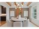 Bright dining room with modern light fixture, wood beam ceiling, and elegant decor at 2810 Herrington Dr, Cumming, GA 30041