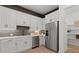 A modern kitchen featuring white cabinetry, stainless steel appliances, and a gray backsplash at 2810 Herrington Dr, Cumming, GA 30041