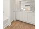 Modern bathroom featuring a double sink vanity, wood-look flooring, and a large mirror at 4183 Viola Pl, Atlanta, GA 30349