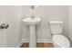 Modern bathroom with a sleek pedestal sink, round mirror, and a toilet at 4183 Viola Pl, Atlanta, GA 30349